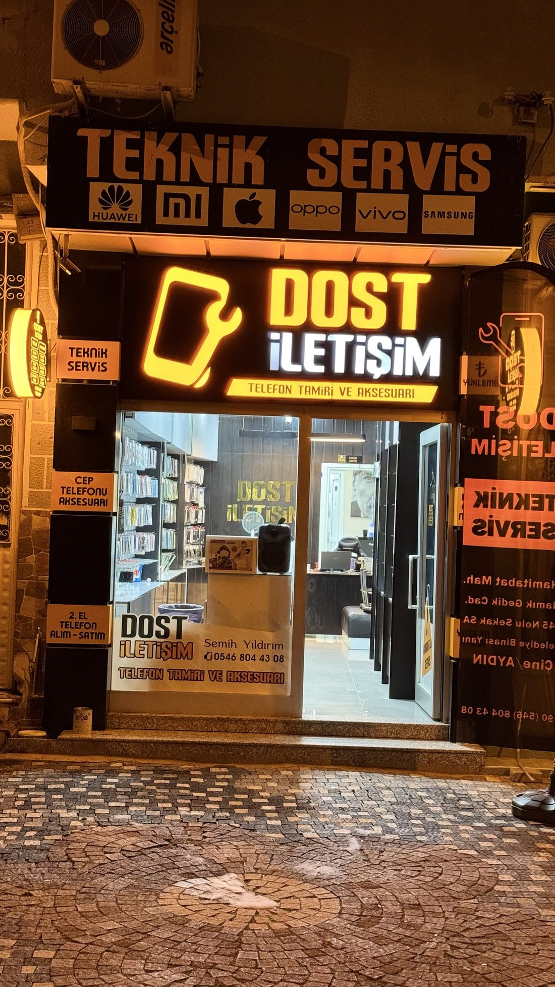 Dost İletişim dükkanının geceleri ışıklı girişi